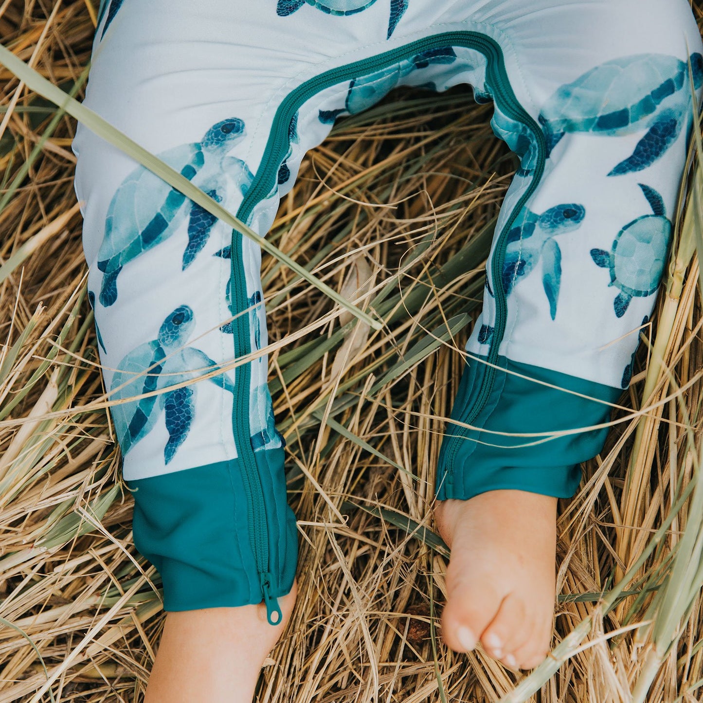 UPF 50+ protective full length, long sleeve swimsuit. Turtle print with zipper that goes around the legs of the suit making nappy changes very easy.